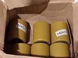 quatre rouleaux de ruban adhésif dans une boîte en carton posée sur une table