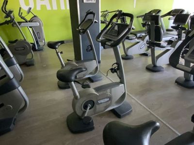 des rangées de vélos d'appartement dans une salle de sport aux murs verts