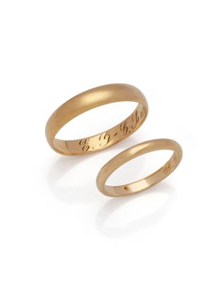 a pair of gold wedding rings with engraved names