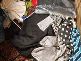 une boîte en carton remplie de vêtements et des vêtements par terre