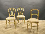 trois chaises dans une pièce aux murs gris et au sol en parquet