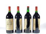 trois bouteilles de vin rouge sont alignées sur une surface blanche