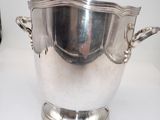 a large silver bowl with handles on a table