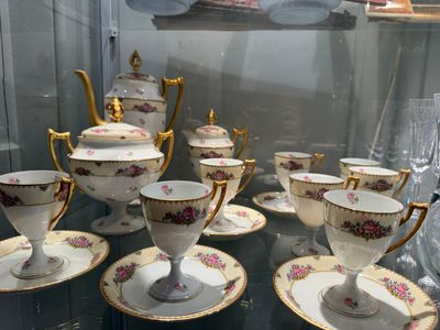 many cups and saucers on display in a glass case