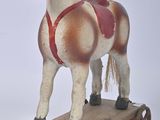 un cheval en bois posé sur une charrette en bois