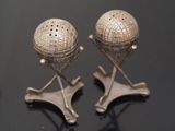 pair of silver salt and pepper shakers on stand on black surface