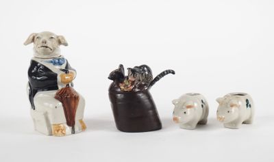 three figurines of dogs and a cat sitting on a chair