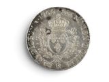an old silver coin with a crown on it on a white surface