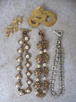 trois paires de bijoux en or et perles posés sur un fond blanc