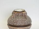 a brown and white vase sitting on a white surface