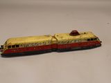 un petit train jaune et rouge posé sur une surface blanche
