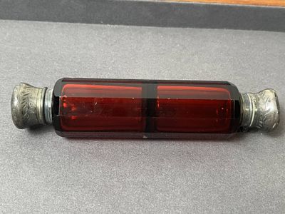 une bouteille en verre rouge munie d'un bouchon en métal