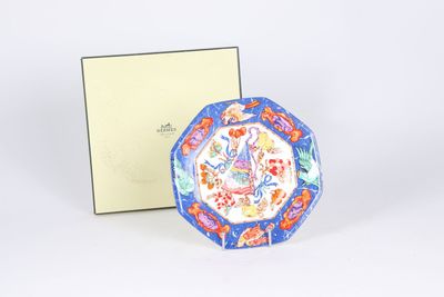 a blue and red plate sitting next to a white box