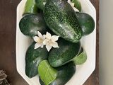 a bowl of cucumbers on a table with pine cones