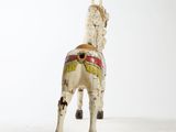a toy horse that is standing on a white surface