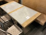 une table avec des chaises et un banc dans un restaurant