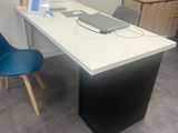 a desk with a computer on it and a blue chair