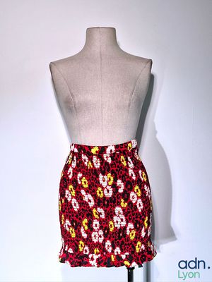 un mannequin vêtu d'une jupe à motifs floraux rouges et jaunes