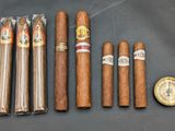 five cigars are lined up next to a compass on a table