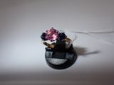 a ring with a pink and blue stone on top of it