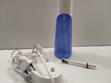 a toothbrush, toothpaste, and toothpaste dispenser on a table