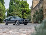 an image of a classic car parked on a cobblestone road