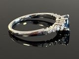 an image of a diamond and sapphire ring on a black surface
