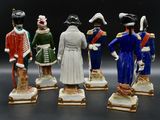 several figurines of men dressed in military uniforms stand in a row