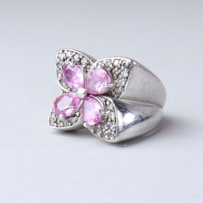 silver ring with pink stones and clear crystals on a white background