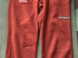the north face flee pants are red and have white logos on them