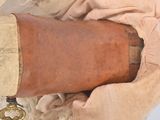 a woman holding a large brown vase with a gold handle