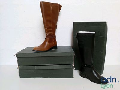 a pair of boots sitting on top of a stack of books