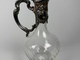 un pichet ancien en verre plaqué argent sur fond blanc