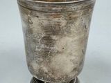 a silver cup that is sitting on top of a table
