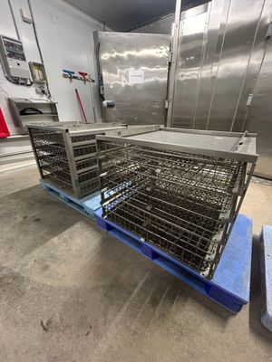 une grande cage métallique posée sur une palette dans une cuisine