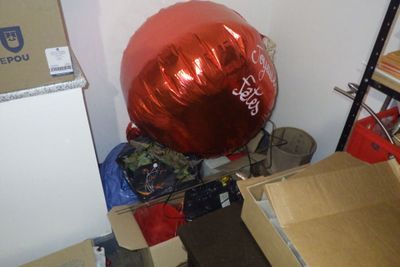 un gros ballon rouge posé au sommet d'une pile de cartons