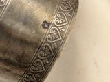 a silver vase that has a decorative design on it
