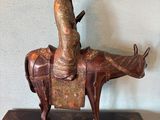 statue of a man riding a horse with a hat on top of it