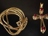 un gros plan sur un collier et une croix posés sur une table