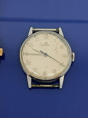 une montre posée sur une surface bleue, à côté d'un briquet