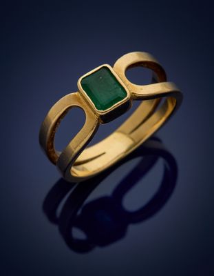 a gold ring with a green stone in the middle