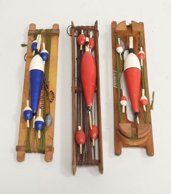 three wooden toy boats on display on a white surface