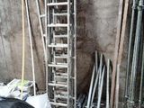 a pile of tools and a ladder in the corner of a room