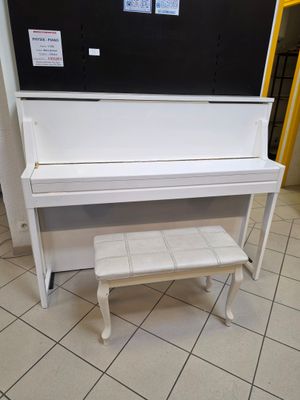 un piano blanc et un banc dans une pièce