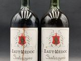 two bottles of red wine sitting next to each other on a table