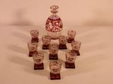 bottles and cups are arranged in a circle on a white surface
