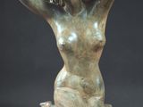 statue of a woman sitting on a rock with her hands behind her head