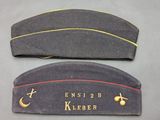 two military hats with the names of two different countries on them