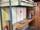 un lit superposé avec un bureau en dessous, dans une chambre