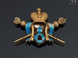 a close up of a gold and blue broochle on a black background
